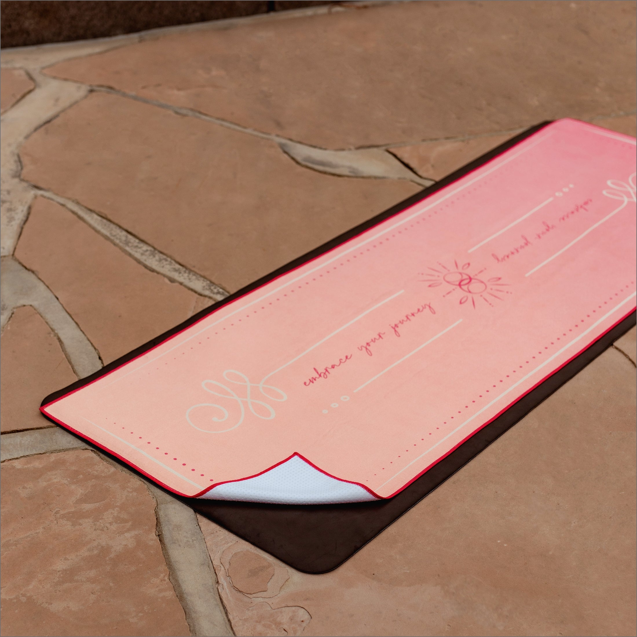 Silicone grip backing detail of Unalome Glow towel — white silicone dots beneath coral-pink surface for non-slip hot yoga performance