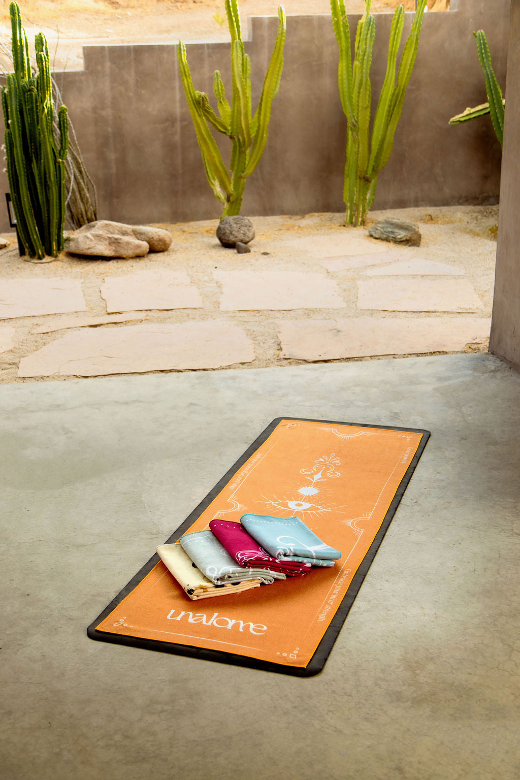 Assorted Unalome hot yoga towels from the Grounded Collection – eco-friendly, high-grip towels in earthy tones with mindful, symbolic designs