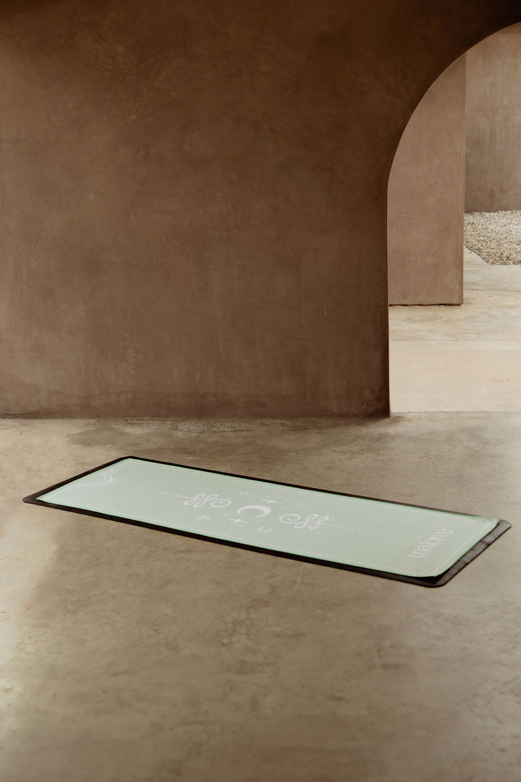 Light green non slip yoga towel displayed in full with white symbols 